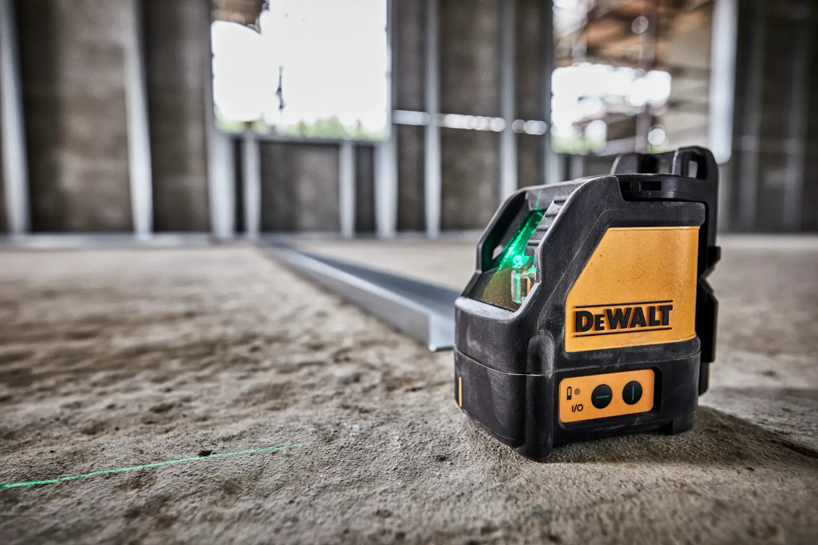 A DEWALT DW088CG laser line generator device in black and yellow, shown with warning and compliance labels. The device has a sturdy black casing and two metallic strips on the side.